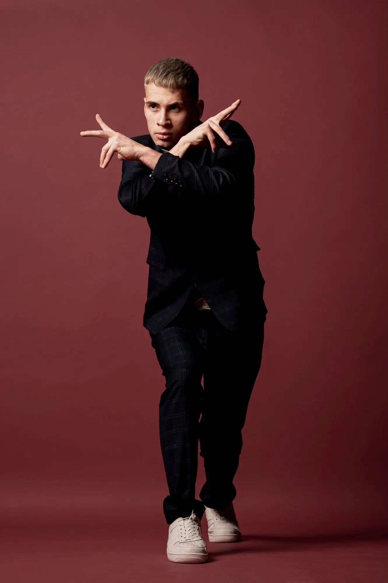 Männlicher Tänzer im Anzug und in Turnschuhen, der posiert.